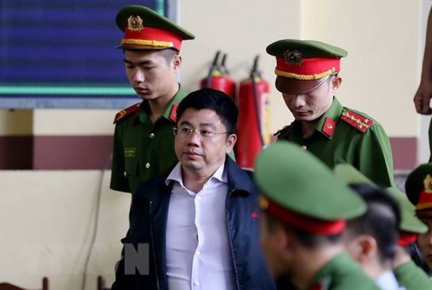  Lực lượng chức năng dẫn giải bị cáo Nguyễn Văn Dương vào phiên tòa. (Ảnh: Trung Kiên/TTXVN)