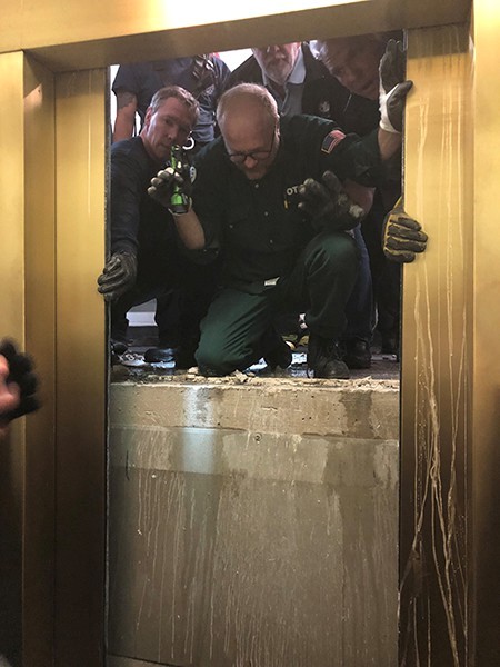 Lực lượng cứu hộ phá tường mở cửa thang máy. Ảnh: ABC 7 Chicago