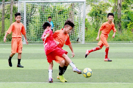  Pha tranh bóng trong trận chung kết bóng đá nam, TP Vĩnh Long (áo đỏ) trước Vũng Liêm.