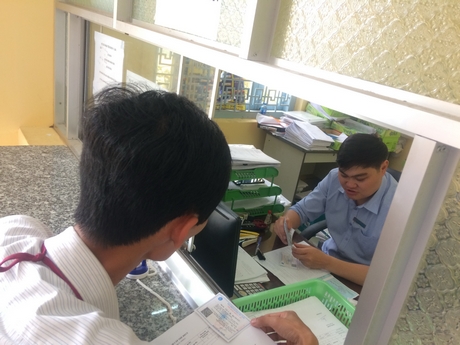 Cán bộ UBND thị trấn Trà Ôn nhận thẻ BHYT tại cơ quan BHXH huyện về trao cho người dân.
