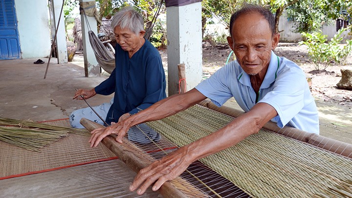 Dù tuổi đã cao, vợ chồng ông Lê Văn Ðiều vẫn gắn bó với nghề dệt chiếu.