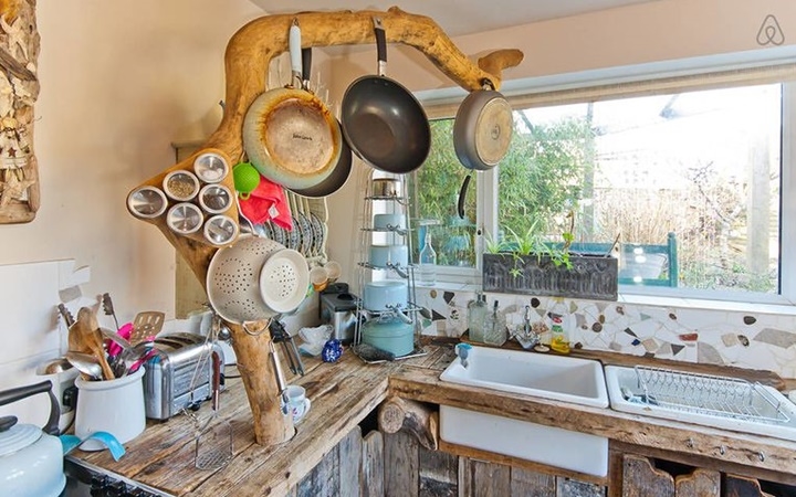 Phòng bếp với giá treo nồi, chảo cực độc, giống với chạc cây mà cú mèo hay đậu.