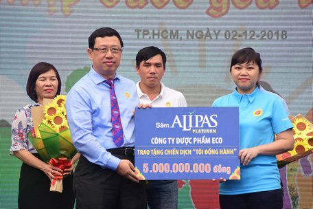 Đại diện công ty dược phẩm Eco (trái) trao tượng trưng 5 tỉ đồng cho chiến dịch 'Tôi đồng hành' tại Ngày hội hoa hướng dương 2/12 - Ảnh: DUYÊN PHAN