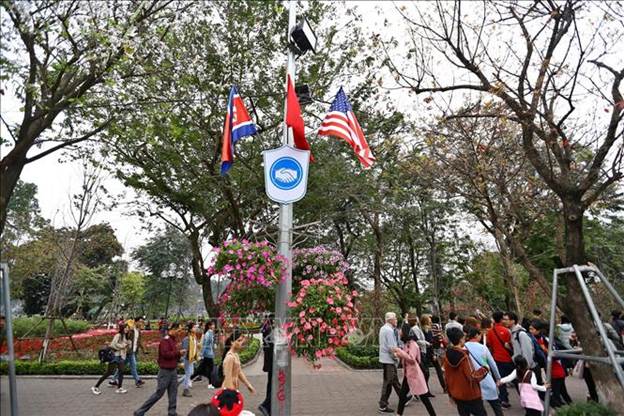 Biểu tượng bắt tay thể hiện thông điệp hòa bình của cuộc gặp gỡ của hai nhà lãnh đạo Mỹ - Triều Tiên xuất hiện cùng với quốc kỳ của hai nước và quốc kỳ Việt Nam treo quanh hồ Hoàn Kiếm.