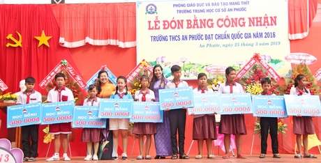 Đại diện lãnh đạo huyện Mang Thít và trường CĐ Kinh tế- Tài chính Vĩnh Long trao học bổng cho các em học sinh.