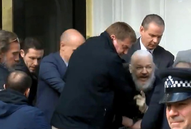Ông Assange khi bị bắt. Ảnh: RT