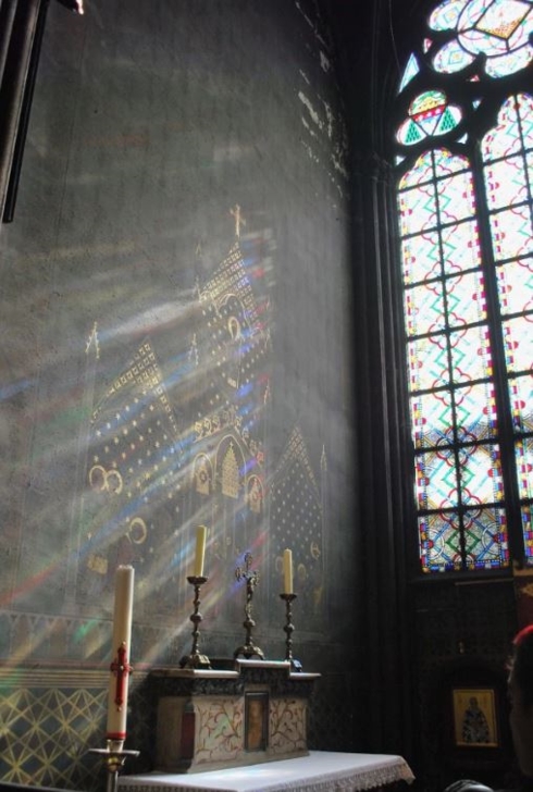 Ánh nắng chiếu qua những ô cửa kính màu tạo nên những ray sáng tuyệt đẹp phản chiếu trên tường trong Nhà thờ Đức Bà.