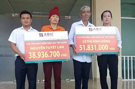 Ông Võ Văn Hoàng- đại diện ABIC (bên trái) và bà Lê Thị Ngọc Thảo- Phó Giám đốc Agribank Phòng giao dịch Cái Ngang (bên phải) trao biểu trưng chi trả bảo hiểm cho gia đình các khách hàng.