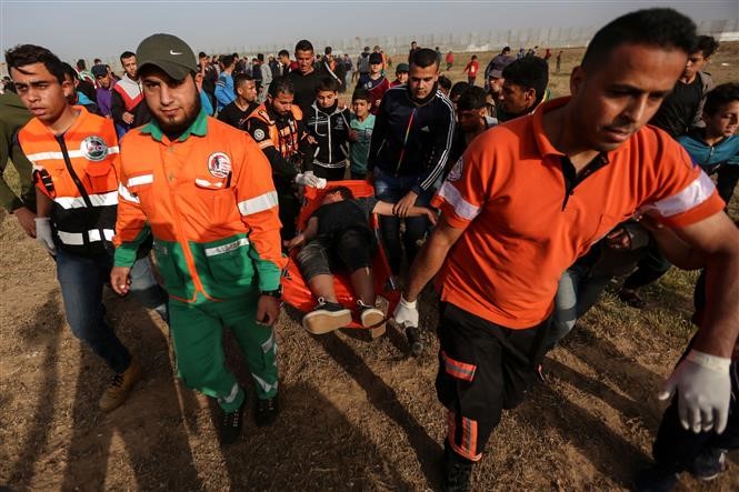 Người biểu tình Palestine bị thương trong các vụ đụng độ với lực lượng an ninh Israel tại miền Đông Dải Gaza ngày 26/4. Ảnh: THX/TTXVN