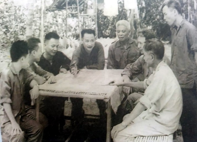 Trung tướng Trần Văn Trà- Tư lệnh Bộ chỉ huy miền Nam (người đang chỉ tay trên bản đồ) và Tham mưu trưởng Lê Đức Anh (người ngồi bên phải Trung tướng Trần Văn Trà) trong cuộc họp Bộ chỉ huy miền Nam tại Căn cứ Lộc Ninh (Bình Phước) năm 1972.