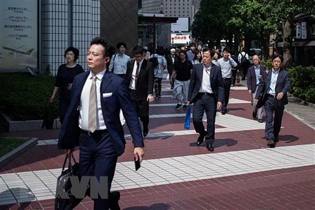  Người dân di chuyển trên đường phố Tokyo, Nhật Bản. (Ảnh: AFP/TTXVN)