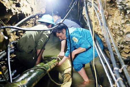 Lực lượng cứu hộ hút nước dưới hang sâu để tìm cách đưa thi thể nạn nhân ra ngoài