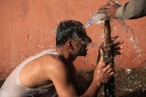 Một người đàn ông “giải nhiệt” tại một vòi nước ở TP Lahore - Pakistan hôm 2/6. Ảnh: REUTERS