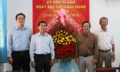 Ông Nguyên Hữu Khánh- Phó Tổng Biên tập Báo Vĩnh Long nhận hoa chúc mừng từ Phó Hiệu trưởng Trường ĐH Sư phạm Kỹ thuật Vĩnh Long Lê Hồng Kỳ (thứ 2 từ trái qua)