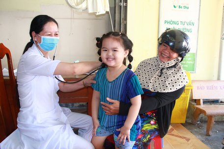 Trẻ em tiêm ngừa vắc xin sởi- rubella khám sức khỏe sau tiêm tại Trạm Y tế Phường 2 (TP Vĩnh Long).
