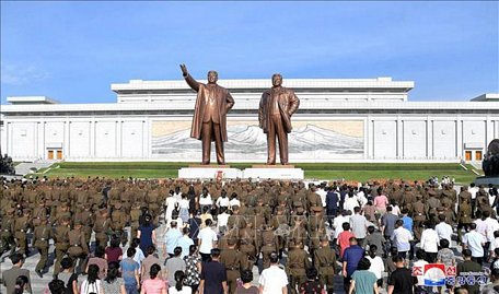 Người dân Triều Tiên cúi đầu dành phút mặc niệm trước hai bức tượng của hai cố Chủ tịch Kim Nhật Thành và Kim Jong-il trong buổi lễ kỷ niệm 25 năm ngày mất của lãnh tụ Kim Nhật Thành ở Bình Nhưỡng ngày 8/7/2019. Ảnh: Yonhap/TTXVN