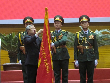 Đồng chí Trần Quốc Vượng trân trọng gắn Huân chương Sao vàng lên lá cờ truyền thống.