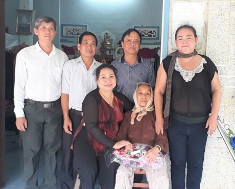 Nhà báo Phạm Hoàng Khải- Tổng Biên tập Báo Vĩnh Long (đứng thứ hai từ phải sang) chụp hình cùng mẹ Khéo và lãnh đạo địa phương.