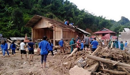 Đoàn viên thanh niên huyện Quan Sơn, Thanh Hóa phối hợp với lực lượng vũ trang giúp bà con bản Sa Ná, xã Na Mèo dựng lại nhà cửa sau trận lũ lịch sử đầu tháng 8/2019. (Ảnh: TTXVN)