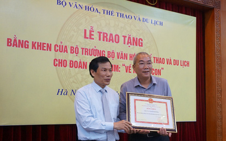 Bộ trưởng Nguyễn Ngọc Thiện trao bằng khen cho đạo diễn Danh Dũng, đạo diễn phim Về nhà đi con - Ảnh: NGỌC DIỆP