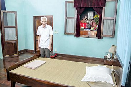  Ông Trần Viết Hoàn bên chiếc giường Bác nằm những ngày cuối đời trong nhà 67 (Ảnh: tư liệu)