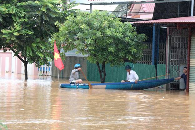 Người dân thị trấn Lao Bảo, Hướng Hóa, Quảng Trị dùng thuyền di chuyển khi đường phố bị ngập lũ. (Ảnh: Nguyên Lý/TTXVN)