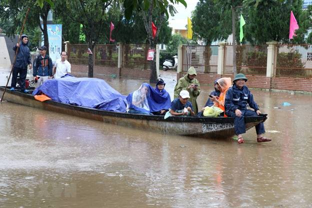 Người dân thị trấn Lao Bảo, Hướng Hóa, Quảng Trị dùng thuyền di chuyển đồ dùng tránh lũ. (Ảnh: Nguyên Lý/TTXVN)