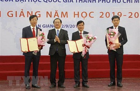 Phó giáo sư Huỳnh Thành Đạt, Giám đốc Đại học Quốc gia thành phố Hồ Chí Minh trao các quyết định bổ nhiệm lại hiệu trưởng, phó hiệu trưởng Trường Đại học An Giang. (Ảnh: Thanh Sang/TTXVN)