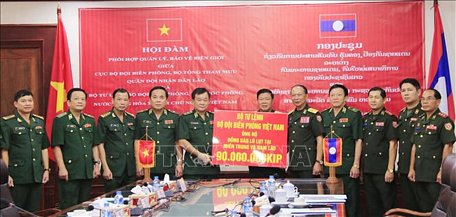 Trung tướng Hoàng Xuân Chiến (thứ 5, từ trái sang), Tư lệnh Bộ đội Biên phòng Việt Nam, trao tiền ủng hộ người dân bị thiệt hại tại các tỉnh Trung và Nam Lào cho Bộ Quốc phòng Lào. Ảnh: Xuân Tú/Pv TTXVN tại Lào