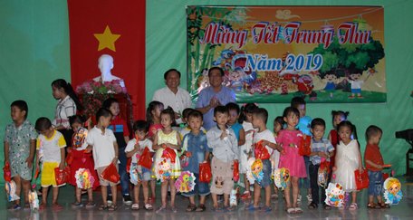 Ông Trần Hoàng Tựu- Phó Chủ tịch UBND tỉnh và ông Trần Văn Hên- Giám Sở Nội vụ  cùng chụp hình lưu niệm với các cháu thiếu nhi.