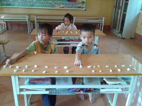 Học sinh Trường tiểu học Minh Tân (Bảo Yên, Lào Cai) học ngữ âm với những viên sỏi. Mỗi tiếng các em nghe, được đánh dấu bằng một viên sỏi - Nguồn: Trường tiểu học Minh Tân