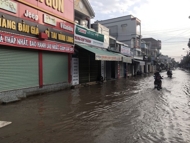 Sáng 6 giờ 30, phần lớn các cửa hàng trên đường Nguyễn Thị Minh Khai, 30 Tháng 4, Mậu Thân… đều đóng cửa khi triều cường. Nước dâng cao, người xe lưu  thông khó khăn.