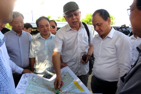  Ông Nguyễn Đức Kiên (người đội nón) kiểm tra tại hiện trường bản đồ thiết kế và giải phóng mặt bằng cầu Mỹ Thuận 2