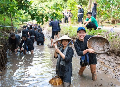 Du khách ở các tỉnh- thành trải nghiệm dịch vụ tát ao bắt cá tại xã cù lao An Bình.