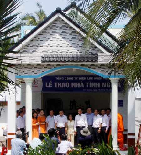 Đại diện Tổng Công ty Điện lực Miền Nam, Công ty Điện lực Vĩnh Long và chính quyền địa phương chụp ảnh lưu niệm cùng bà Nguyễn Thị Ngọc Em (đứng giữa).