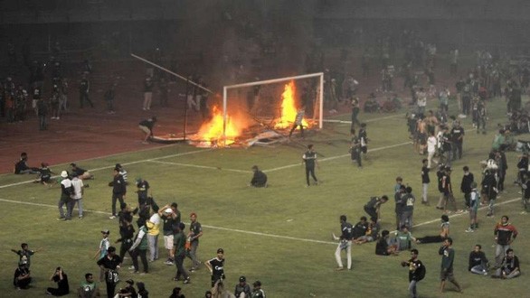 CĐV CLB Persebaya Surabaya đốt cầu môn và biển quảng cáo trên sân Gelora Bung Tomo - Ảnh: BOLA