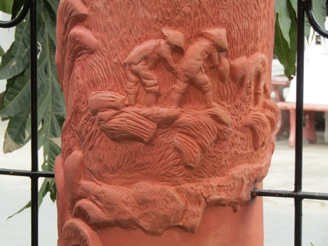 Một cây cột được minh họa bằng hình ảnh sinh hoạt dân gian xưa.