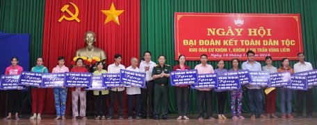 Phó Chủ tịch phụ trách UBND tỉnh- Lữ Quang Ngời (trái) và Chỉ huy trưởng Bộ Chỉ huy Quân sự tỉnh- Đại tá Phạm Văn Bé Tư trao bảng tượng trưng 40 căn nhà đại đoàn kết cho hộ khó khăn về nhà ở.