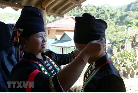  Các thiếu nữ dân tộc Cống chuẩn bị trang phục trước khi làm lễ. (Ảnh: Phan Tuấn Anh/TTXVN)