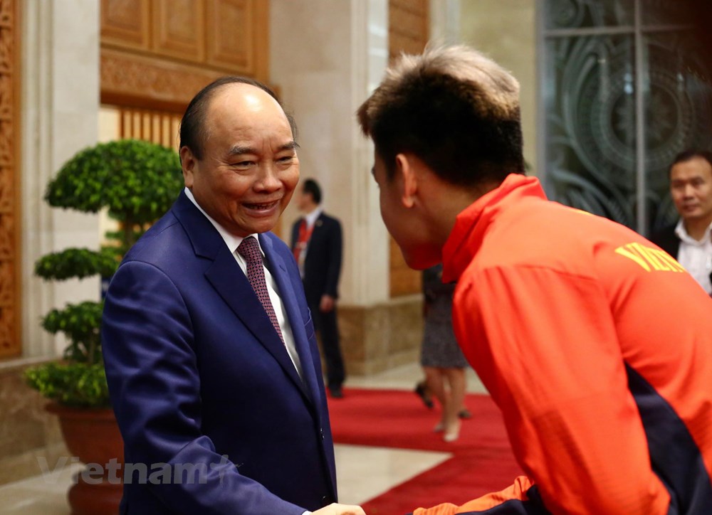 Thủ tướng Nguyễn Xuân Phúc chúc mừng cầu thủ Hồ Tấn Tài. (Ảnh: Nguyên An/Vietnam+)