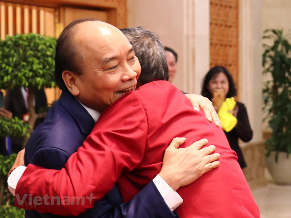 Thủ tướng Nguyễn Xuân Phúc chúc mừng huấn luyện viên Mai Đức Chung. (Ảnh: Nguyên An/Vietnam+)