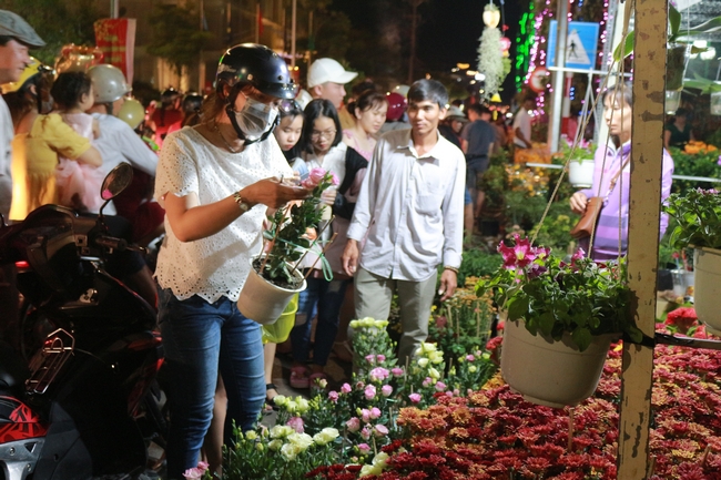 Tại chợ hoa xuân, nhiều người rủ nhau xuống phố chụp ảnh, ngắm và mua