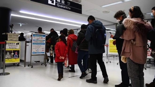 Hành khách từ Vũ Hán được kiểm tra sức khỏe nghiêm ngặt tại sân bay Narita ở Thủ đô Tokyo, Nhật Bản. (Ảnh: AFP)