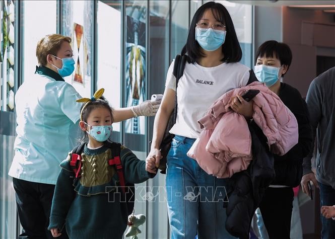  Hành khách đeo khẩu trang đề phòng lây nhiễm virus corona tại sân bay quốc tế Changi, Singapore ngày 22/1/2020. Ảnh: AFP/TTXVN