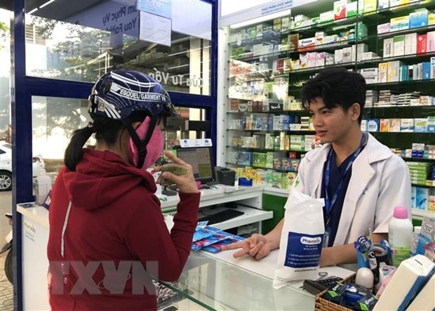 Người dân đến mua khẩu trang y tế và dung dịch rửa tay sát khuẩn tại một cửa hàng thuốc. (Ảnh: Đinh HằngTTXVN)