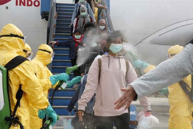 Nhân viên y tế phun thuốc khử trùng vào hành khách đến từ Vũ Hán (Trung Quốc) tại sân bay Hang Nadim ở Batam, Indonesia.