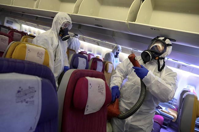 Thành viên phi hành đoàn một máy bay của Thai Airways khử trùng khoang hành khách ngăn chặn lây lan virus Corona mới (nCoV) tại sân bay quốc tế Suvarnabhumi (Bangkok, Thái Lan).