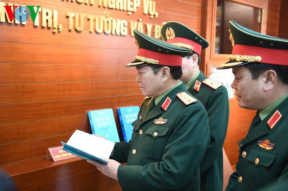 Bộ trưởng Ngô Xuân Lịch kiểm tra các tài liệu Cục Quân y phát hành liên quan đến việc phòng chống dịch bệnh.