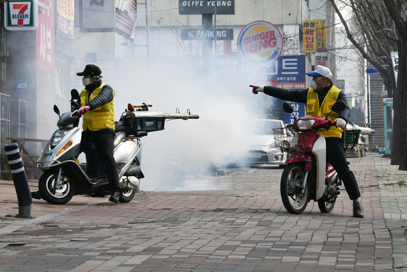 Nhân viên phun thuốc tẩy uế trên đường phố ở Daegu - Ảnh: AFP