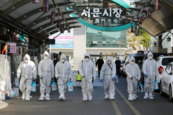 Các nhân viên y tế tẩy uế một khu chợ ở thành phố Daegu ngày 23/2 - Ảnh: AFP